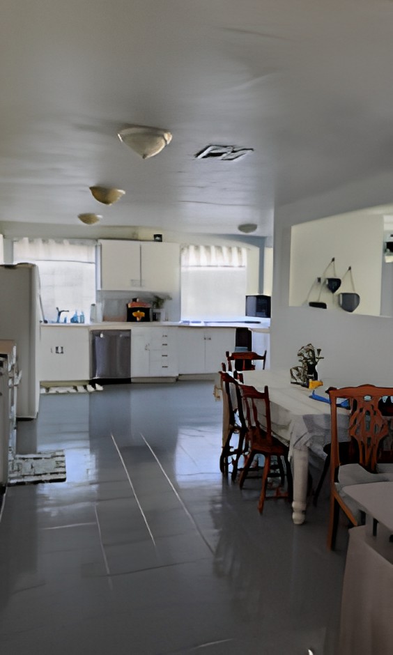 A bright kitchen and dining area with white cabinets and modern appliances.