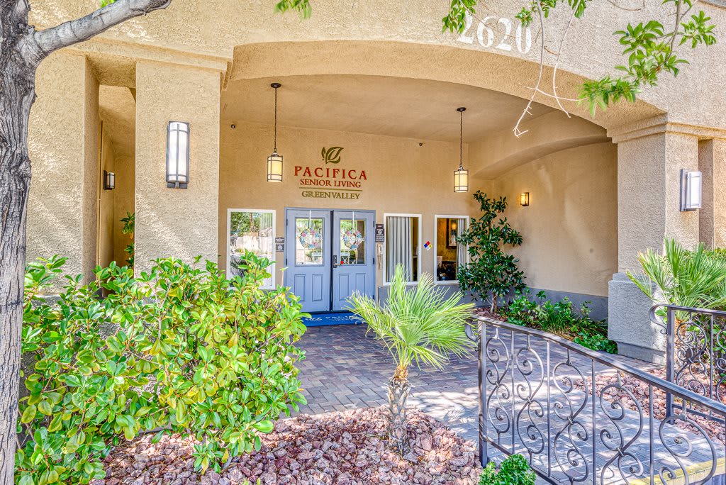 The welcoming entrance of a hotel adorned with greenery and elegant design.