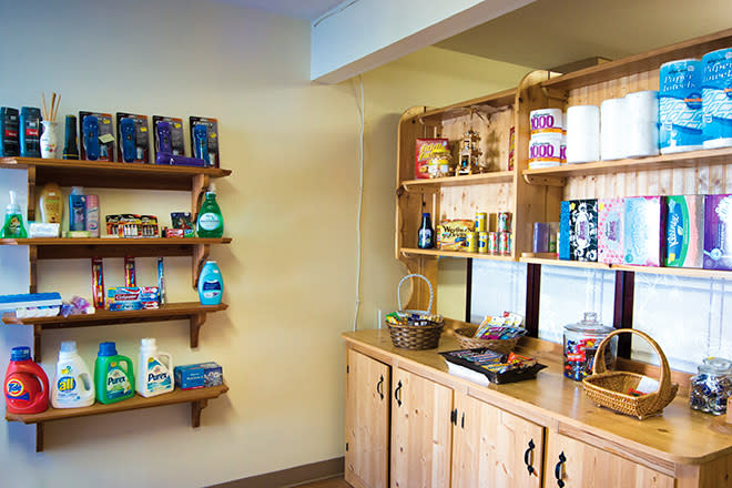 A tidy display of various grocery items on wooden shelves in a retail store.