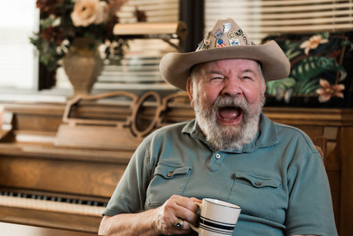 A joyful man enjoying a cup of coffee, surrounded by charming decor.