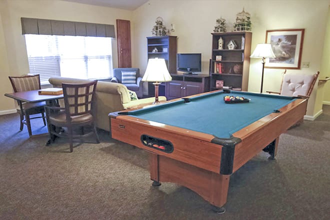 A cozy living room featuring a pool table and comfortable seating.