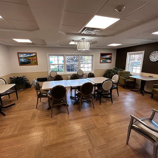 A spacious meeting room designed for gatherings and discussions, featuring a large table surrounded by chairs.