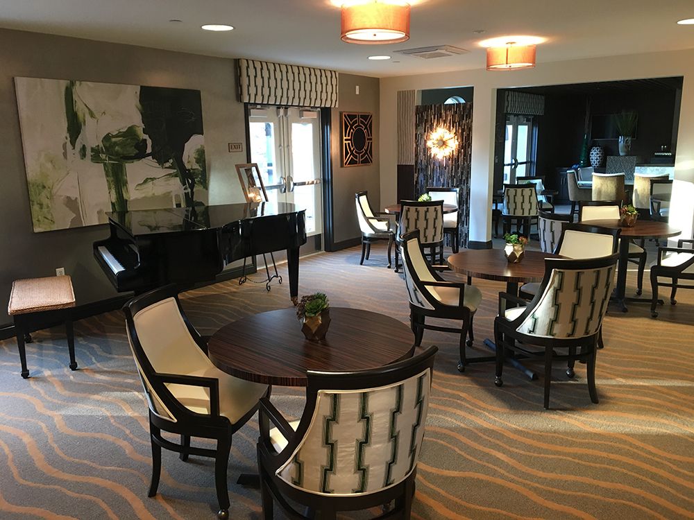 A contemporary lounge area featuring elegant seating, a grand piano, and stylish lighting.