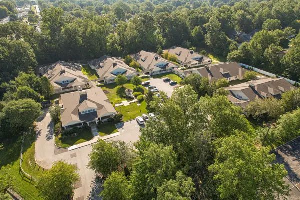 Aerial view of a quiet suburban neighborhood surrounded by trees.