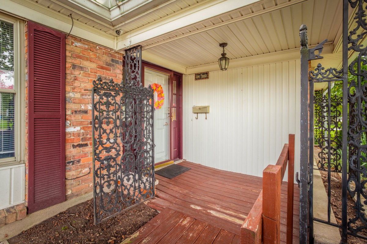 A cozy front porch with a brick wall and decorative elements.