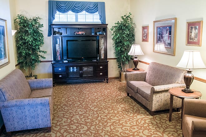 A cozy living room with comfortable seating, a TV stand, and decorative elements.