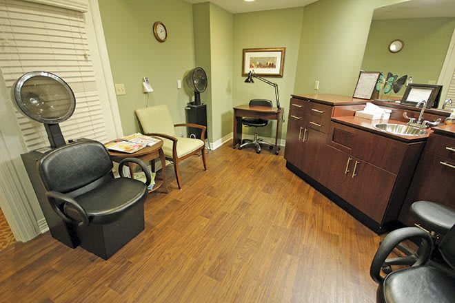 A small waiting room with chairs, a desk, and wooden flooring.