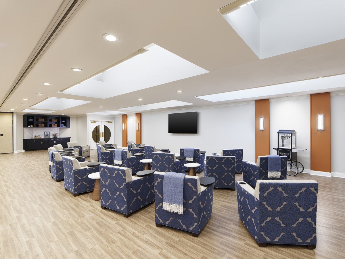 A modern waiting room with comfortable seating and a television.