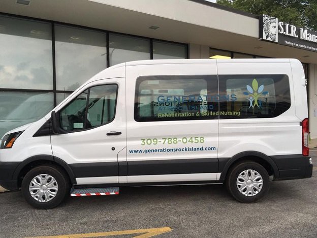 A white passenger van parked outside a building, displaying business contact information and advertising on its side.