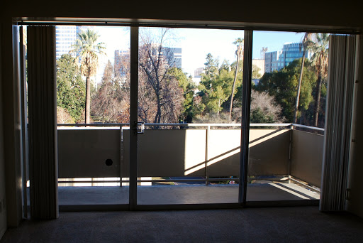 A glimpse of the city through a spacious balcony with large glass windows.