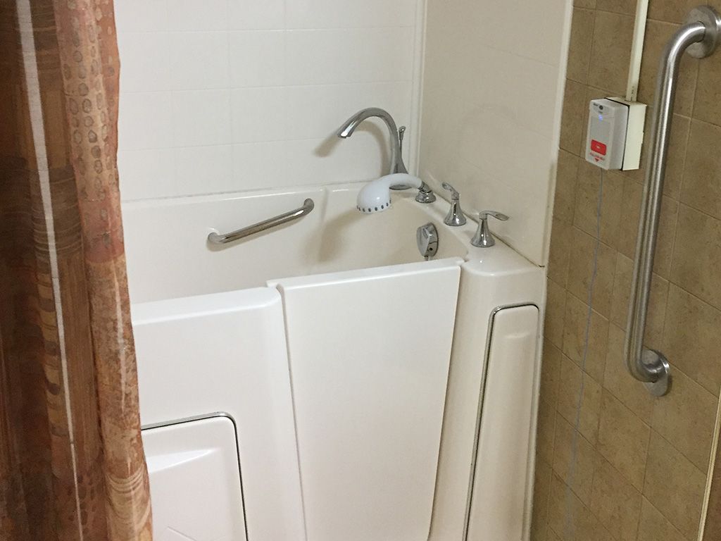 An accessible walk-in bathtub in a bathroom designed for ease of use.