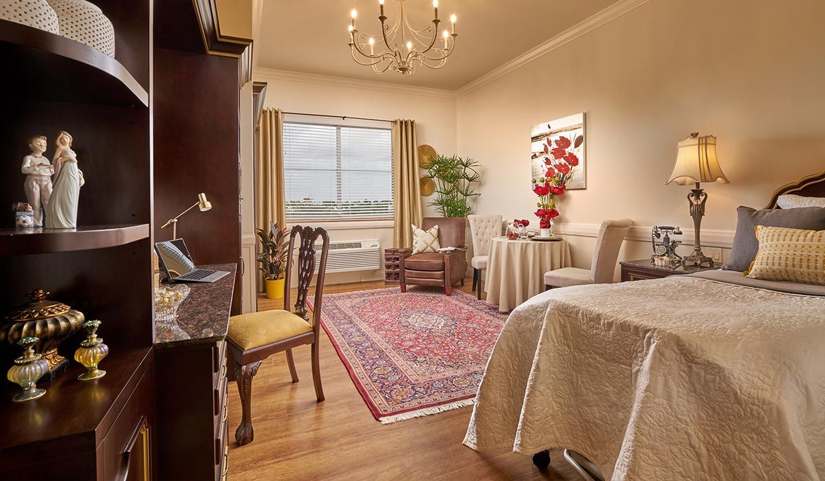 A cozy living room with elegant furnishings, a chandelier, and a large window.