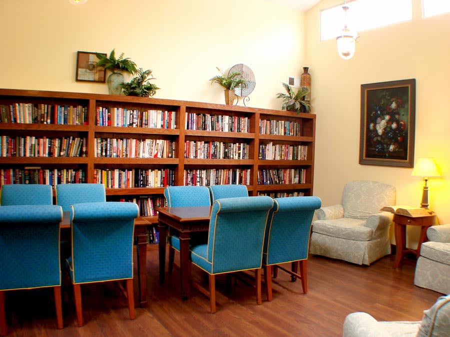 A cozy reading room with bookshelves lined with books and comfortable seating.