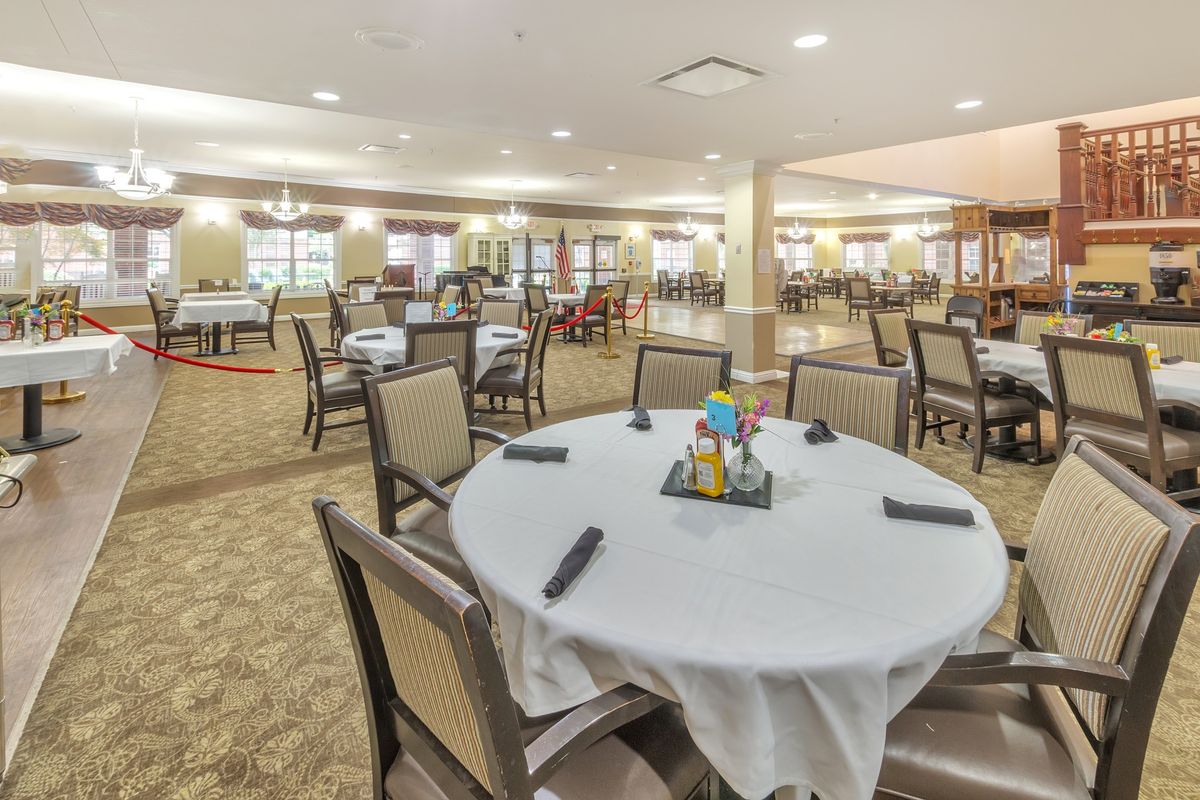 A spacious dining room with neatly arranged tables and chairs, ready for guests.