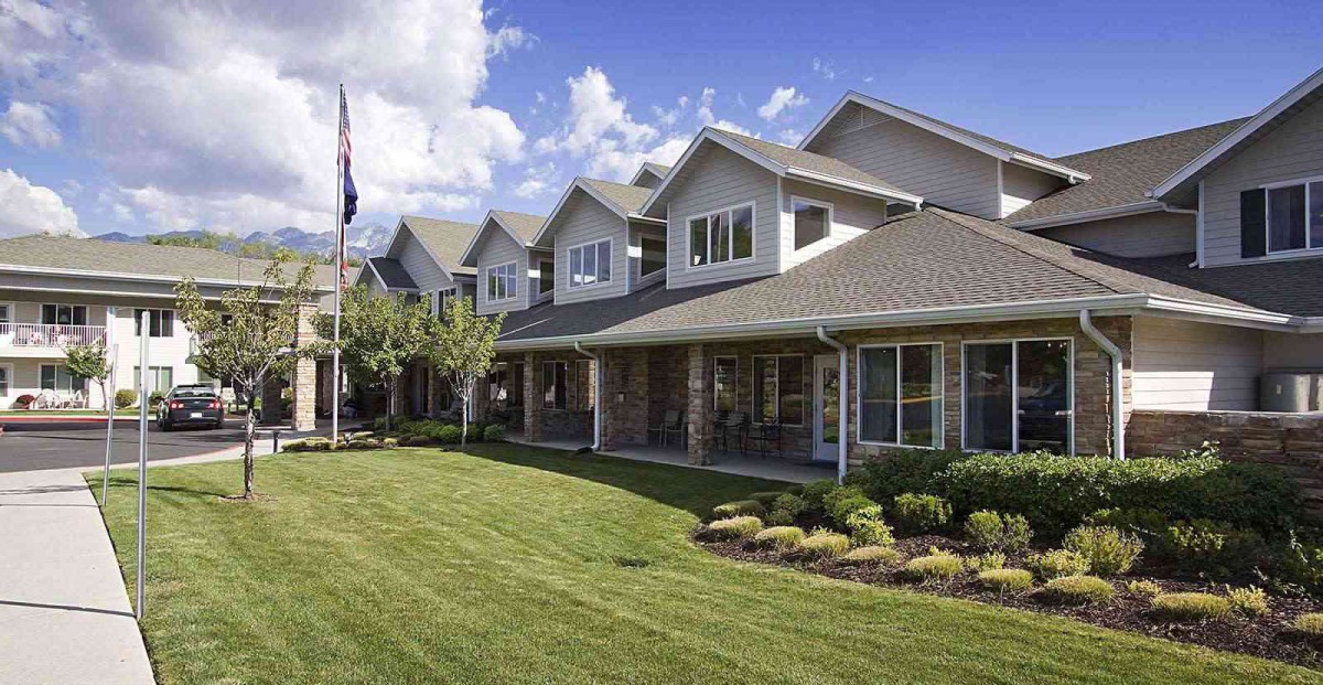 A well-maintained residential building with a manicured lawn and landscaping.