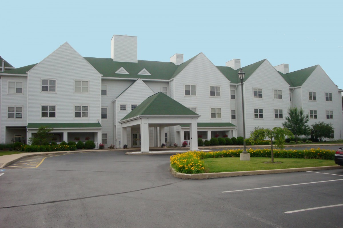 A hotel building with a green roof and landscaped entrance.