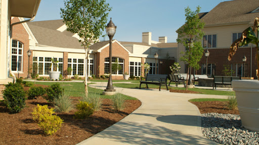 A serene outdoor space featuring a pathway, lush landscaping, and modern architecture.