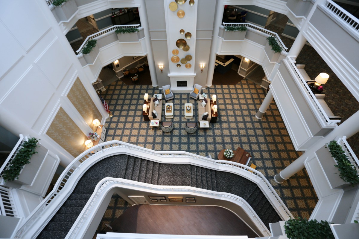 An elegant atrium with a grand staircase in a hotel lobby.