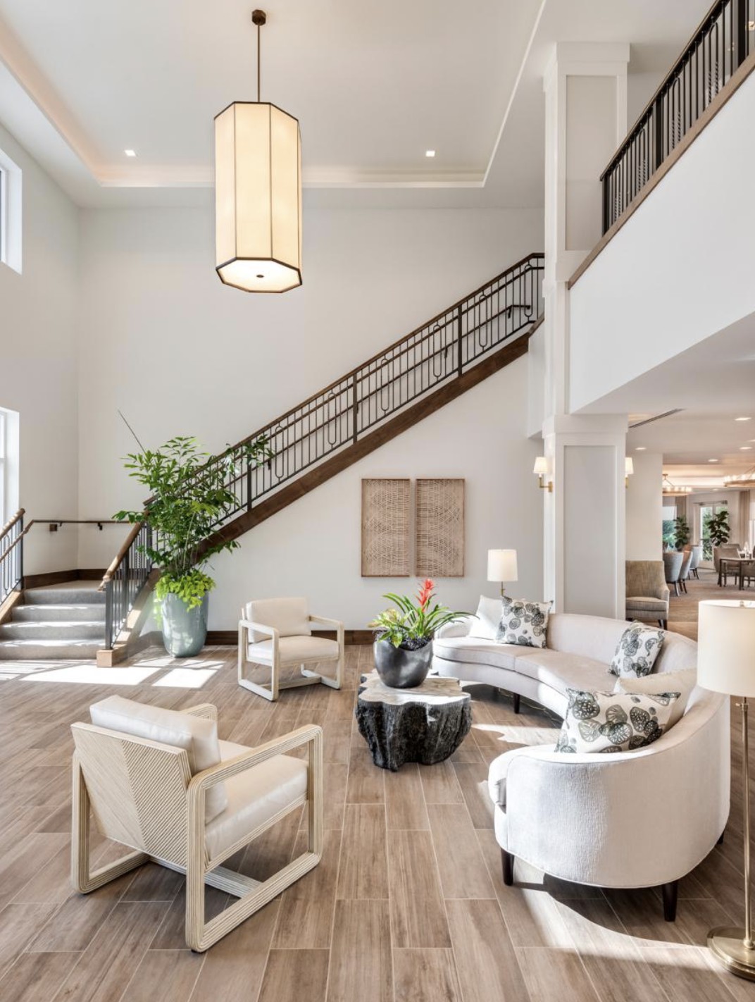 A spacious and modern living room with a sleek staircase and minimalist decor.