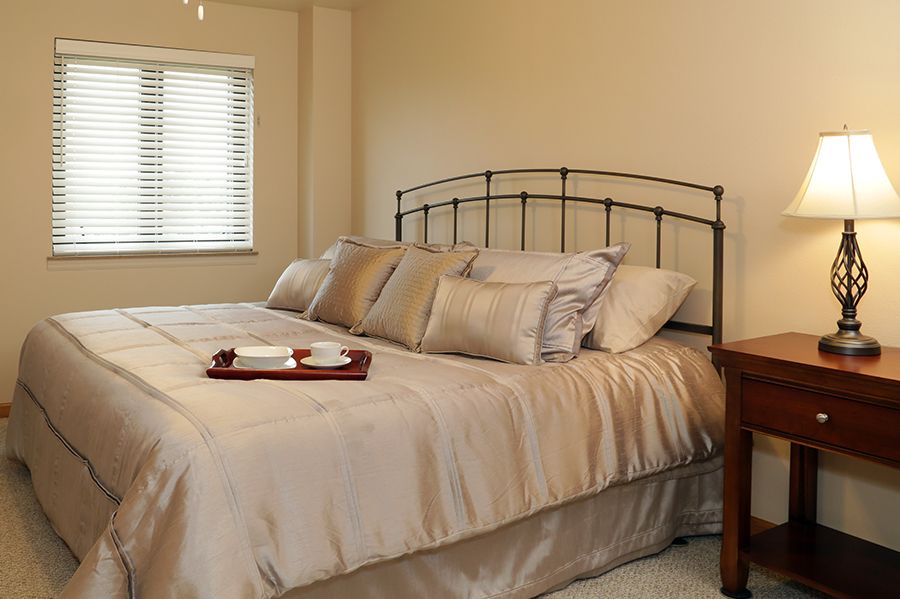 A cozy bedroom with a large bed adorned with pillows and a small tray.