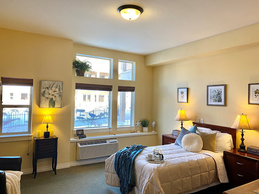 A cozy bedroom filled with natural light, featuring a neatly made bed and tasteful decor.
