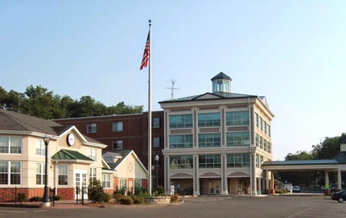 A multi-story commercial building with an American flag flying in front.