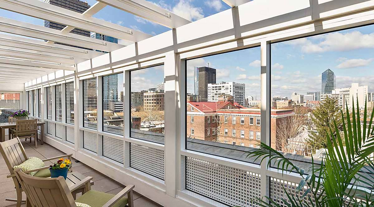 A bright urban cityscape view from a glass-enclosed space on a sunny day.