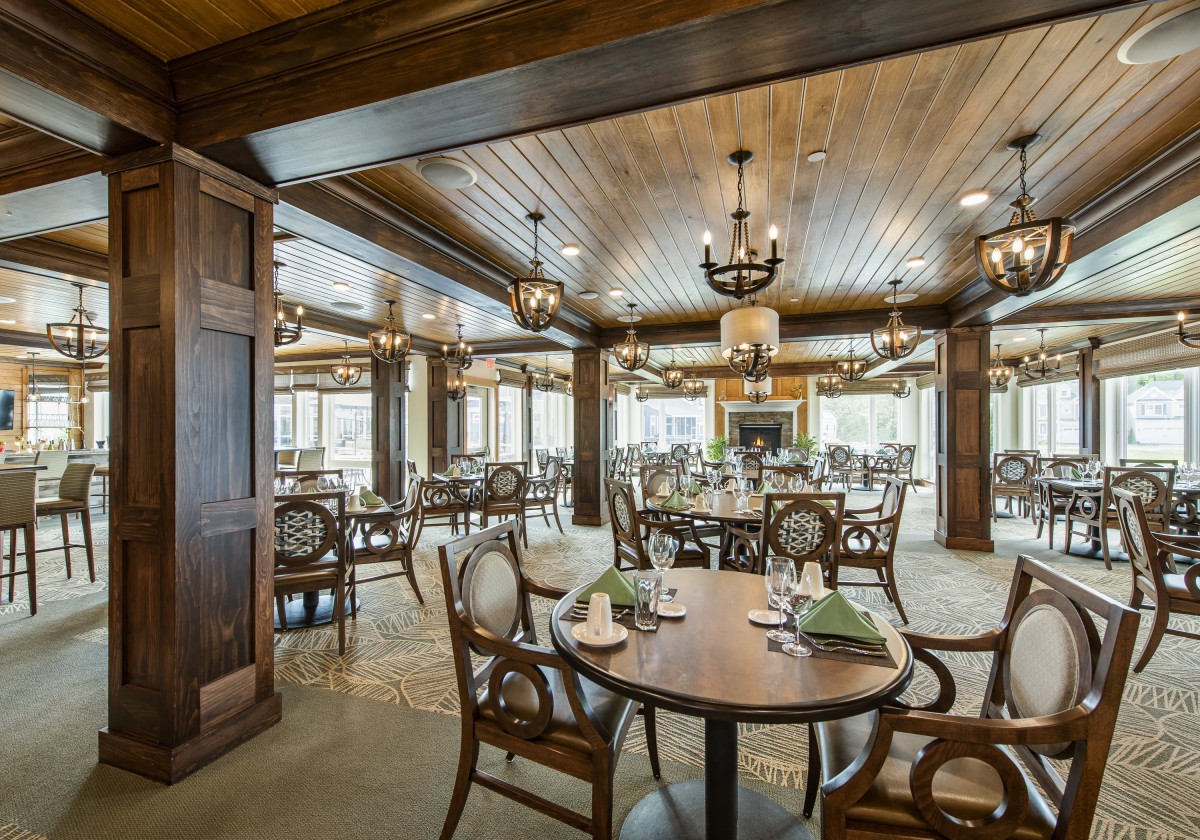An elegant dining room with wooden interiors and chandeliers.