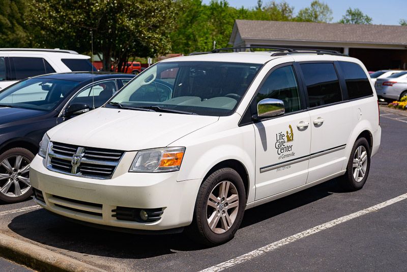 A white Dodge Grand Caravan parked in a parking lot.