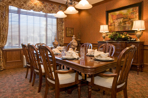 A beautifully arranged dining room featuring a wooden table set for a meal, illuminated by soft lighting.