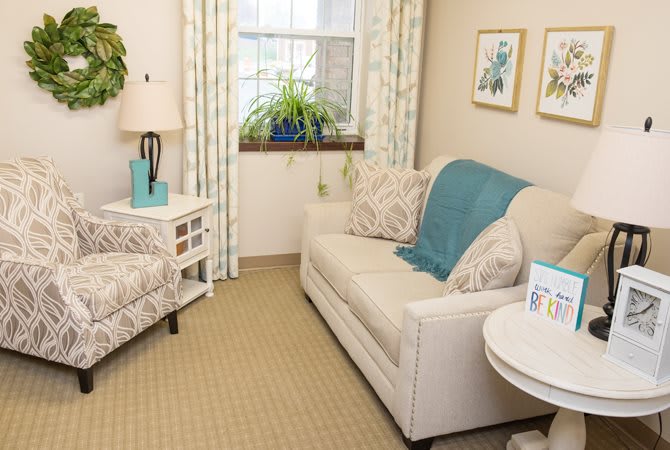 A cozy living room with a sofa, armchair, and decorative elements.