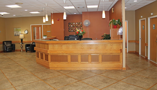 A modern reception area featuring a wooden counter and decorative plants.