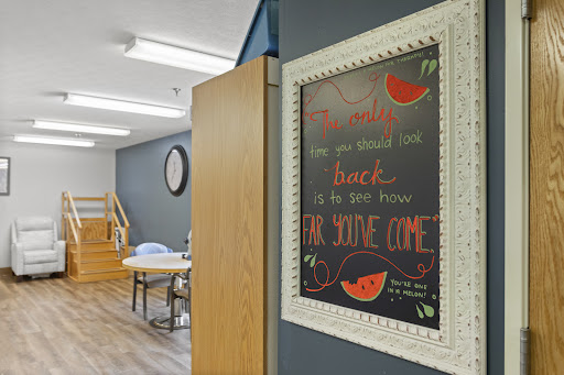 A vibrant chalkboard sign inviting guests to come and enjoy, adorned with artistic watermelon motifs.
