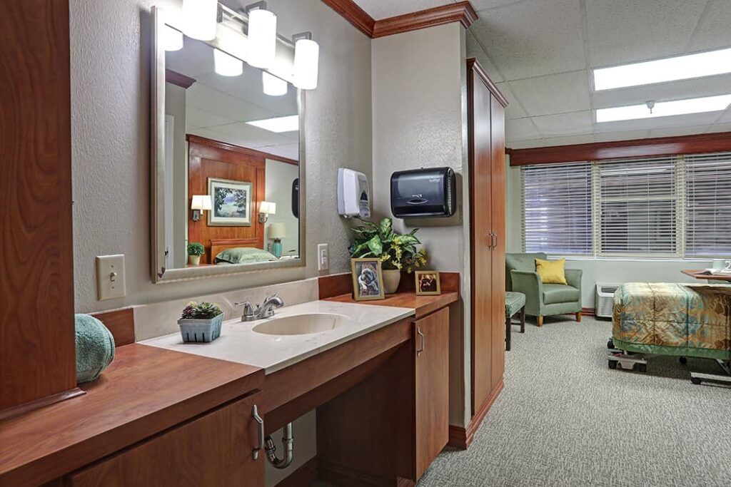A modern bathroom interior featuring a well-lit vanity area with mirror and sink.