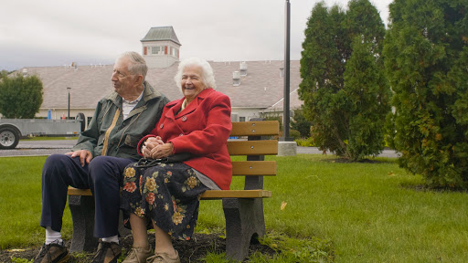 A cheerful senior couple enjoying their time together on a park bench.