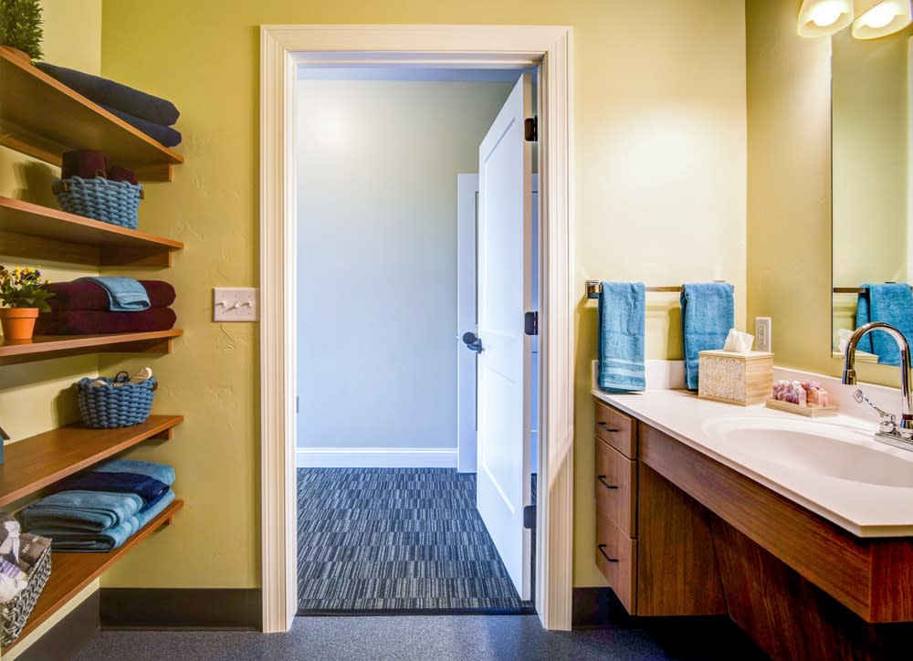 A well-organized bathroom with neatly stacked towels and an open door.