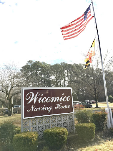 The entrance sign of Wicomico Nursing Home, featuring the American and Maryland flags.