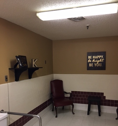 A cozy waiting area featuring a comfortable chair, a bench, and inspirational wall decor.