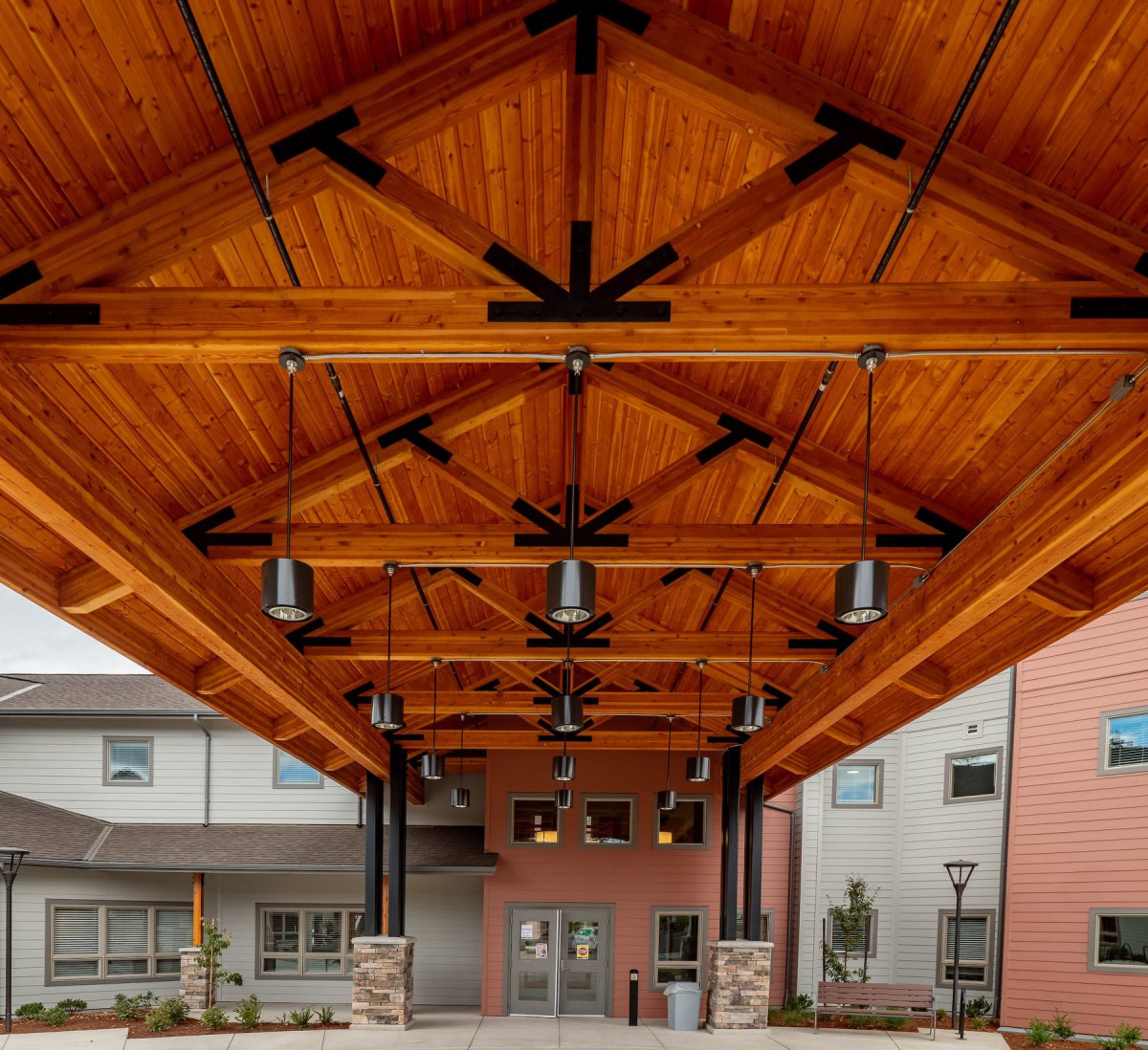 A modern building entrance with an intricately designed wooden ceiling.