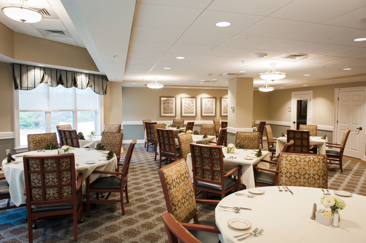 An elegantly decorated dining room with round tables and wooden chairs.