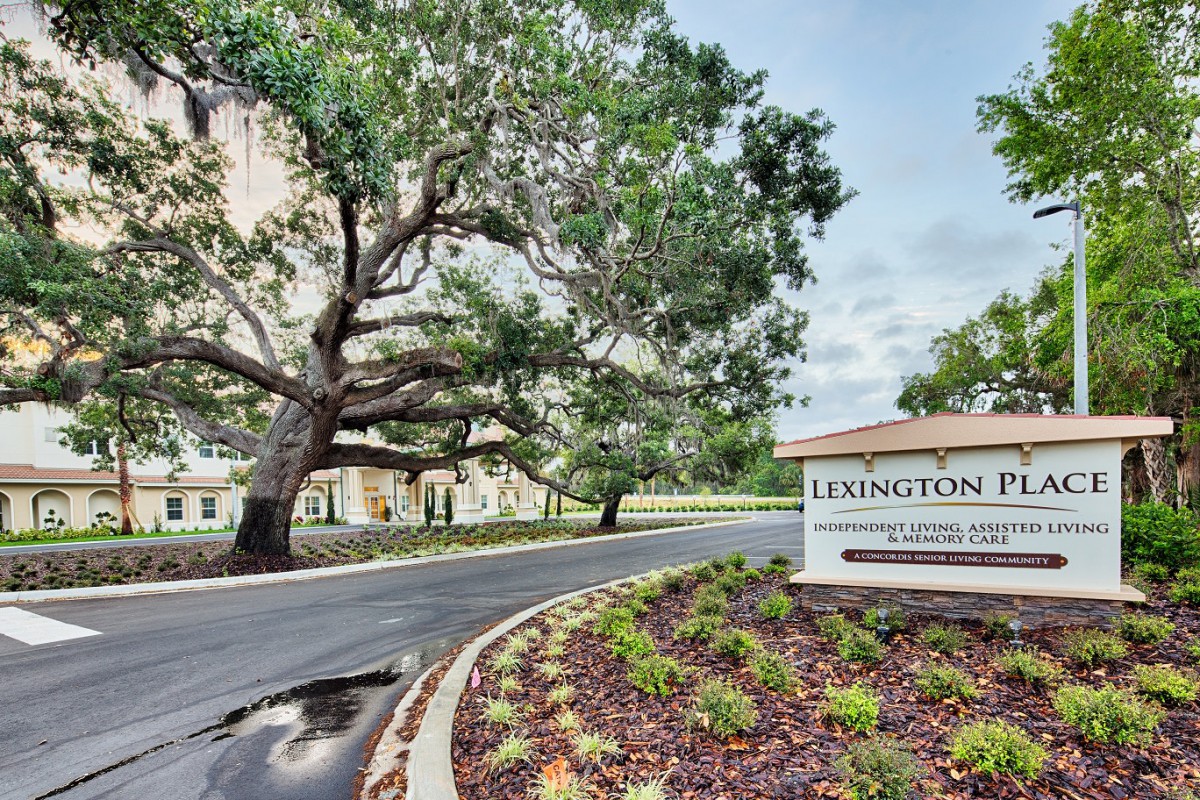 Entrance to a complex with landscaped surroundings and prominent signage.