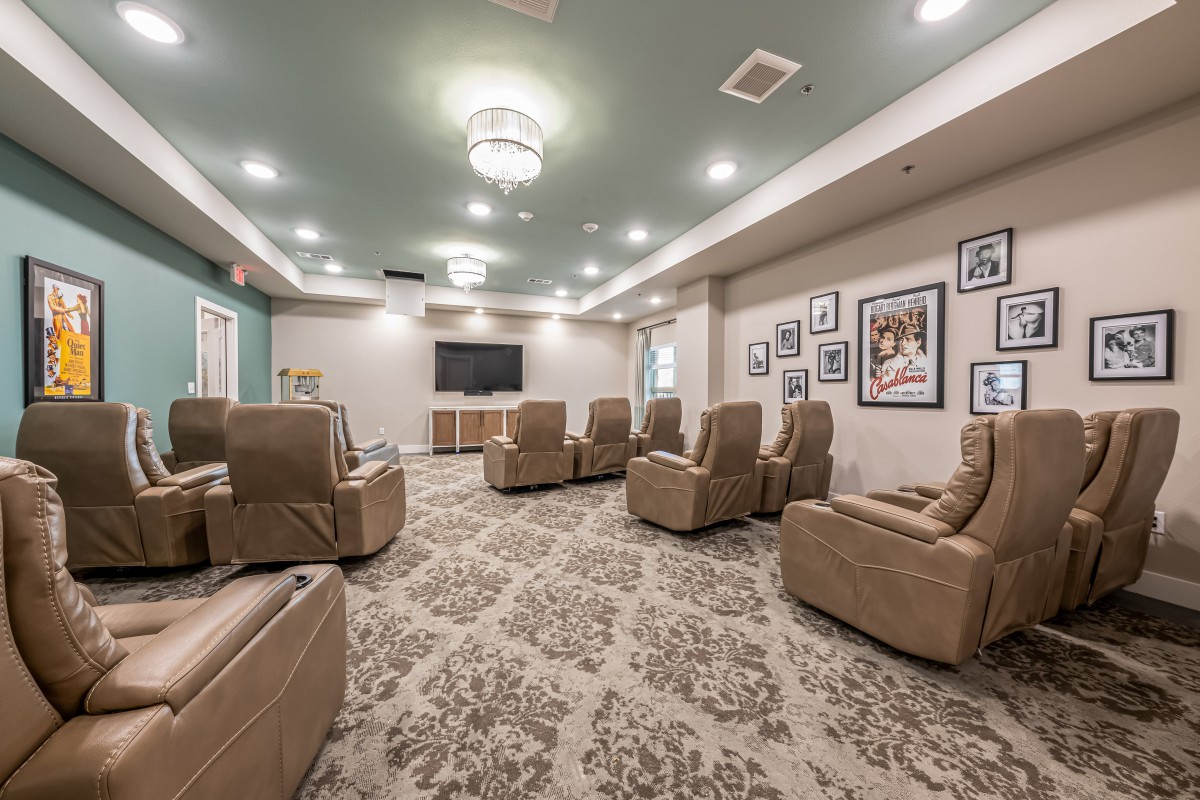 A cozy theater room with comfortable recliners and a large television.