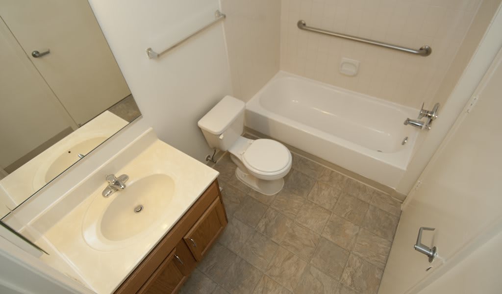 A clean bathroom with a toilet, sink, and bathtub.