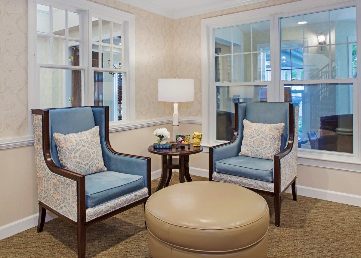 Cozy living room setup with blue armchairs and a beige ottoman.
