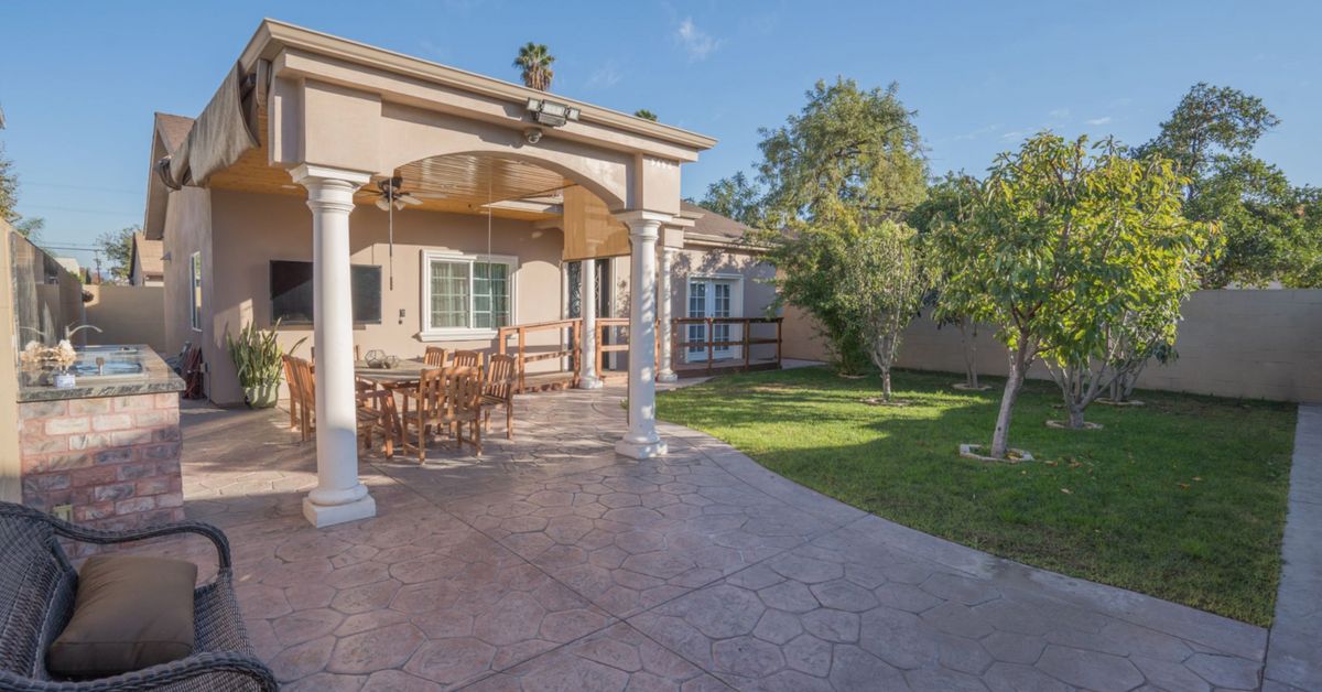 A spacious backyard patio with outdoor furniture and a well-maintained garden.