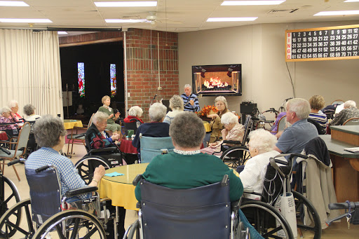 Residents enjoy a musical performance at a nursing home, fostering community and connection.