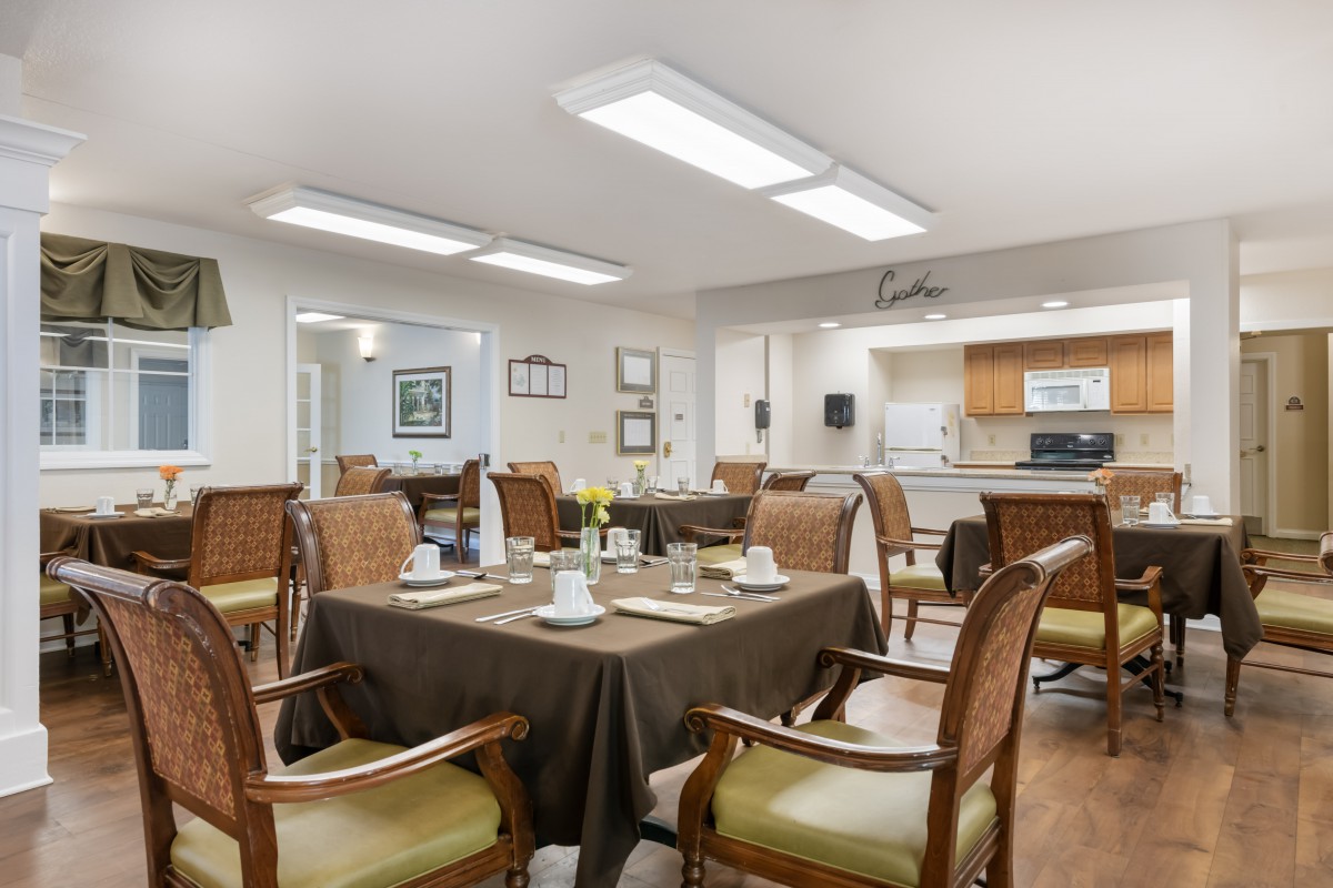 A cozy dining area with neatly arranged tables and chairs, set for a meal.