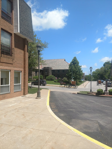 A sunny day showcasing a street view with buildings, trees, and a clear blue sky.
