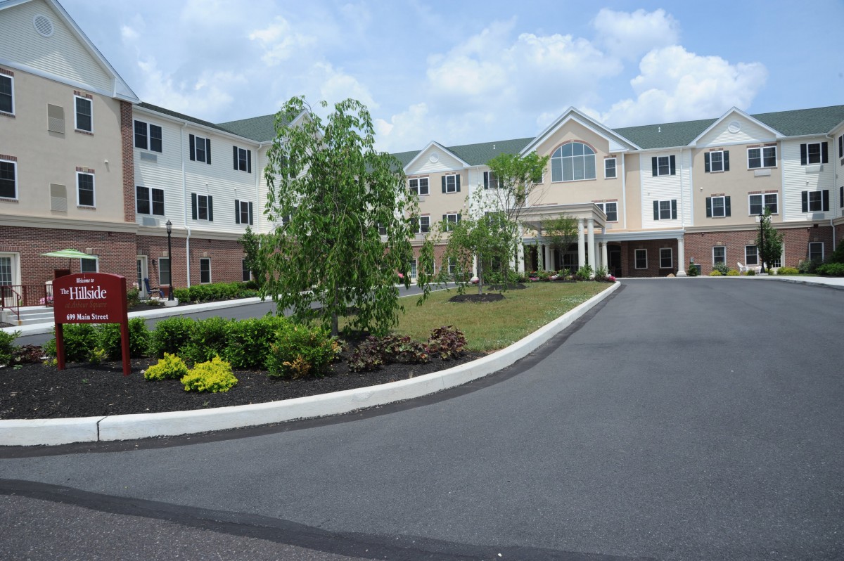 A modern residential building with well-maintained landscaping and a curved driveway.
