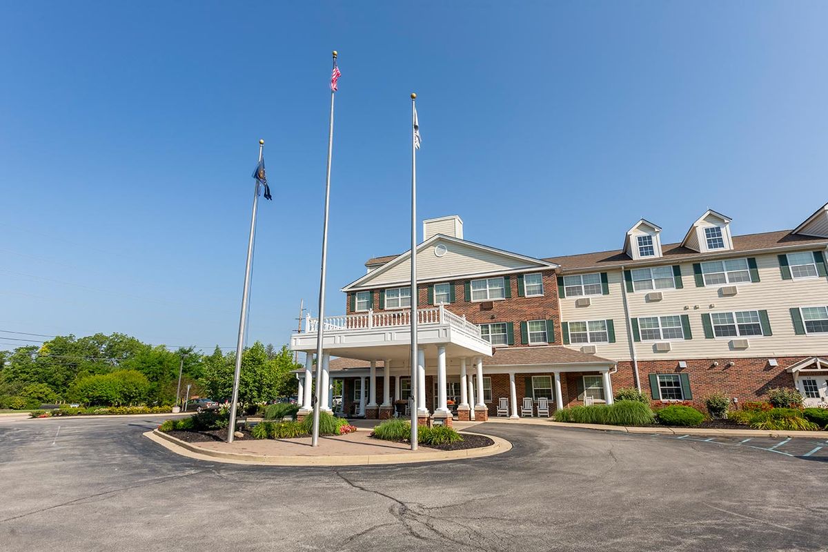 A hotel entrance with flags and a clear blue sky.